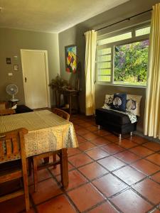 a living room with a table and a window at Villa Dona Jaca - Casa da Mata - 01 in Socorro