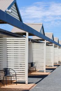 a patio with two benches and a blue roof at Robe Sunset Apartments in Robe