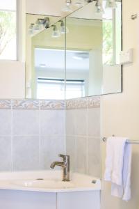 a bathroom with a sink and a mirror at Robe Sunset Apartments in Robe +33 photos