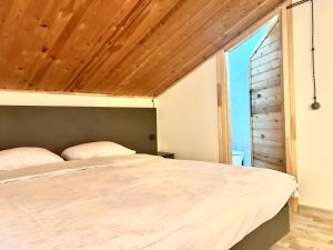 a bedroom with a bed and a wooden ceiling at RestList in Haghpat +8 photos