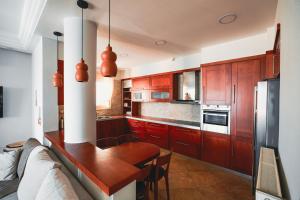 a kitchen with wooden cabinets and a table in it at Villa Kyma in Platána
