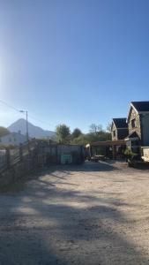 a dirt yard with a house and a fence at Connemara National Park Lodge in Letterfrack