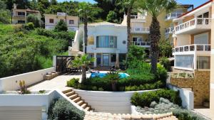 a villa with a swimming pool and palm trees at Villa Kyma in Platána