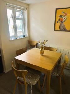 a dining room table with chairs and a vase on it at Charming Kintbury Cottage in Kintbury
