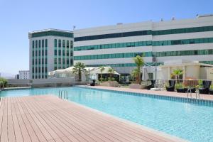 a swimming pool in front of a building at MGM Service Apartment by Savills Oman in Muscat