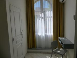 a room with a window with a chair and a desk at Hotel Castellamar in Sainte-Maxime +1 photo