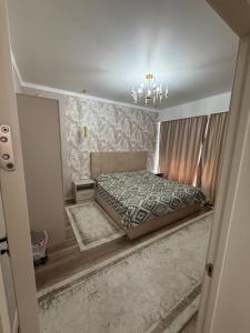 a bedroom with a bed and a chandelier at Берег3 in Bosteri