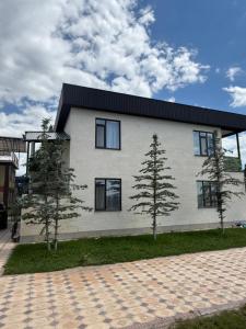 a white house with two trees in front of it at Берег3 in Bosteri