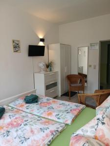 a bedroom with two beds and a desk and a table at Pension Küfner in Markkleeberg