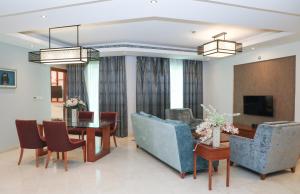 a living room with a table and a dining room at MGM Service Apartment by Savills Oman in Muscat