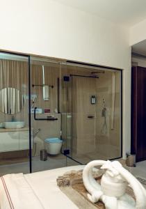 a bathroom with a glass shower and a toilet at Treal Hotels & Suites in Abeokuta +40 photos