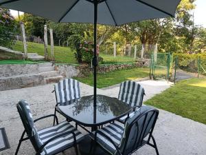 two chairs and a table with an umbrella at Casa en CEDEIRA in Cedeira +42 photos