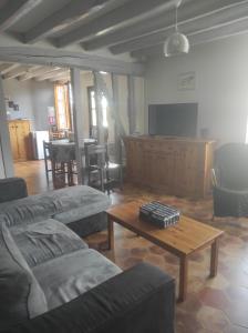 a living room with couches and a table and a tv at Les Rosiers in Onjon