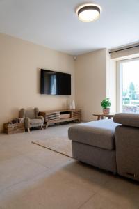 a living room with a couch and a flat screen tv at L'aparté in Rochefort