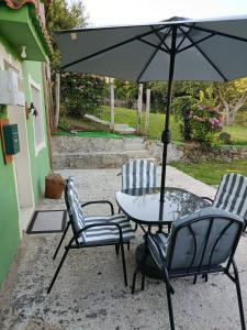 a patio with a table and chairs and an umbrella at Casa en CEDEIRA in Cedeira