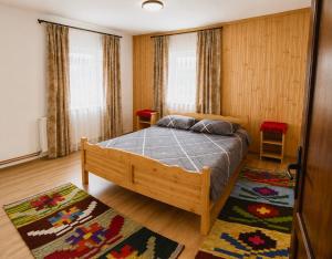 a bedroom with a bed and two windows at Cabana Elena in Gârda de Sus