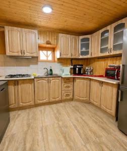 a kitchen with wooden cabinets and a refrigerator at Cabana Elena in Gârda de Sus