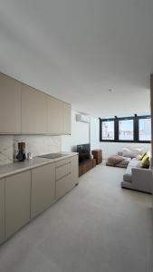 a kitchen with white cabinets and a couch in a room at Avanel Private Pool Penthouse in Ronda