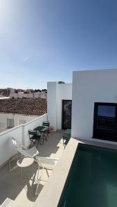 a balcony with chairs and a swimming pool on a building at Avanel Private Pool Penthouse in Ronda