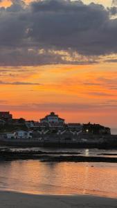 a group of buildings on the beach at sunset at Hotel Josein in Comillas