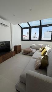 a living room with a couch and a flat screen tv at Avanel Private Pool Penthouse in Ronda