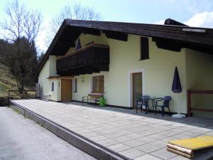 ein Haus mit einer Terrasse davor in der Unterkunft Pension Herzoggut in Zell am See