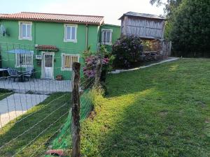 a fence in front of a green house at Casa en CEDEIRA in Cedeira
