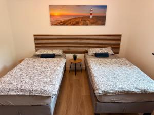 two beds in a room with a lighthouse on the wall at Idar Apartment 2 in Idar-Oberstein
