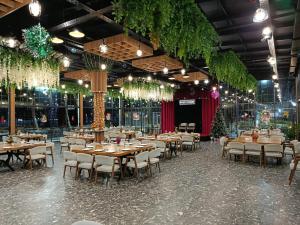 ein Esszimmer mit Tischen und Stühlen und Weihnachtsbäumen in der Unterkunft Rıver Forest Hotel in İsmayıllı
