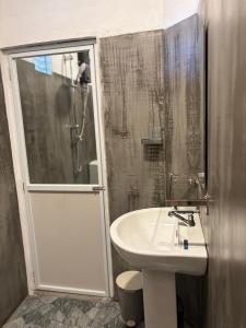 a bathroom with a sink and a shower at The Cottage Weligama in Weligama
