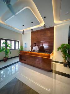 a man sitting at a counter in a room at Hotel Regent DHA in Karachi