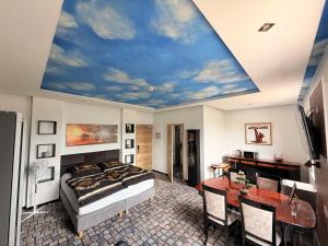 a bedroom with a bed and a ceiling with a sky at Sleep Inn Hotel in Paderborn