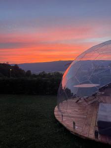 a dome tent sitting in a field at sunset at Chasseral Sky Dome in Twann