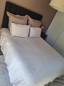 a large bed with white sheets and pillows at 2 chambres d'hôtes in Wissous