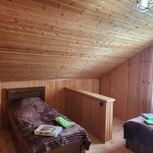 a wooden room with two beds in a cabin at Сабудара in Martvili