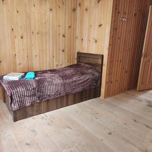 a bedroom with a bed in a wooden wall at Сабудара in Martvili