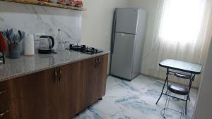 a kitchen with a counter and a refrigerator and a stool at Сабудара in Martvili