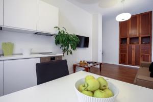 a kitchen with a table with a bowl of apples at Starhost - GOLDEN APARTMENTS in Salerno