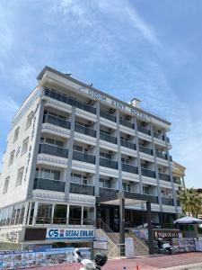 a large white building with a sign on it at KENT HOTEL Didim in Didim