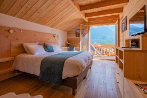 a bedroom with a bed and a large window at Aigle in Le Monêtier-les-Bains