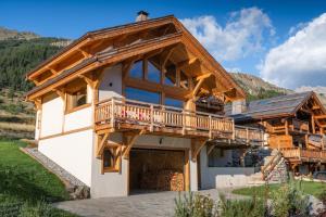 a log home with a balcony on the side at Aigle in Le Monêtier-les-Bains