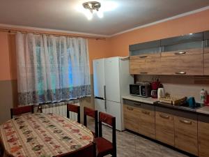a kitchen with a table and a white refrigerator at Kwatery u Potoków in Piwniczna-Zdrój