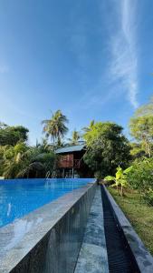 a swimming pool in front of a house at Lakeside Haven Resort in Habarana