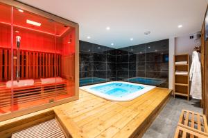 a jacuzzi tub in a bathroom with a red wall at Galibier in Saint-Chaffrey