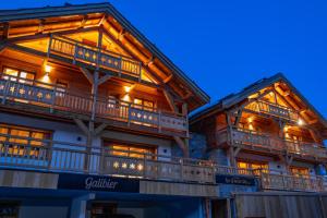 a large wooden building with balconies and lights at Galibier in Saint-Chaffrey