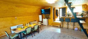 a dining room with a table and chairs at Cabana A frame Nămăiești in Nămăeşti +16 photos