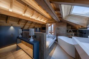 a bedroom with a bed and a sink and a tub at Galibier in Saint-Chaffrey