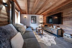 a living room with a couch and a flat screen tv at Galibier in Saint-Chaffrey
