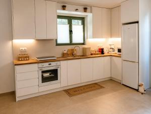 a kitchen with white cabinets and a white refrigerator at Our Kea apartment in Otziás +13 photos