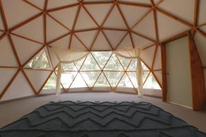 a bedroom with a large window in a yurt at GlampingWoodzen in Villa del Carbón